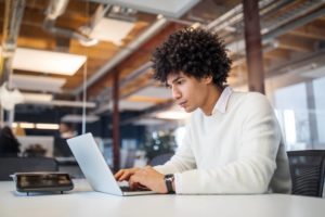 Young businessman using laptop in office